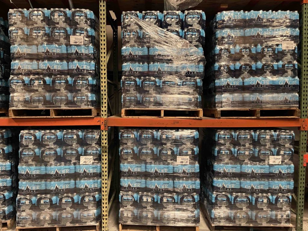 Pallets of bottled water cases on warehouse racks