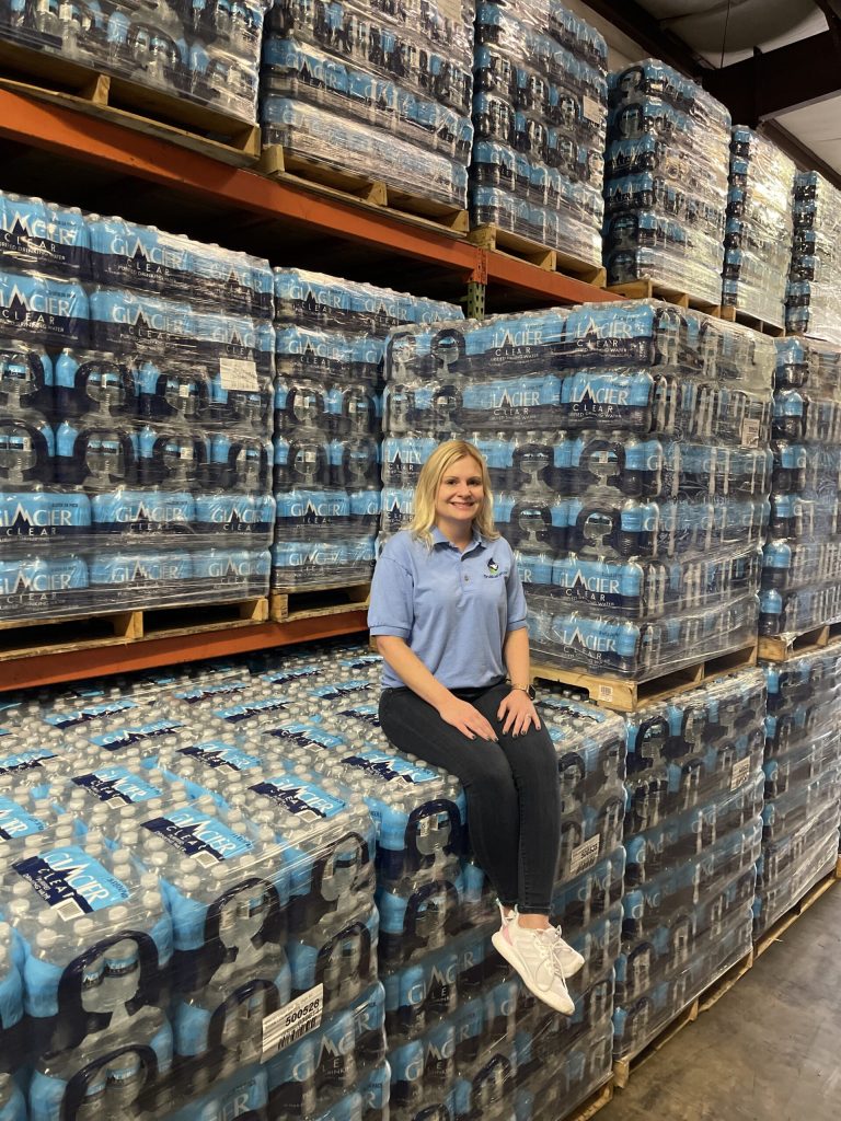 TruBlue Water team member with stacked pallets of case water
